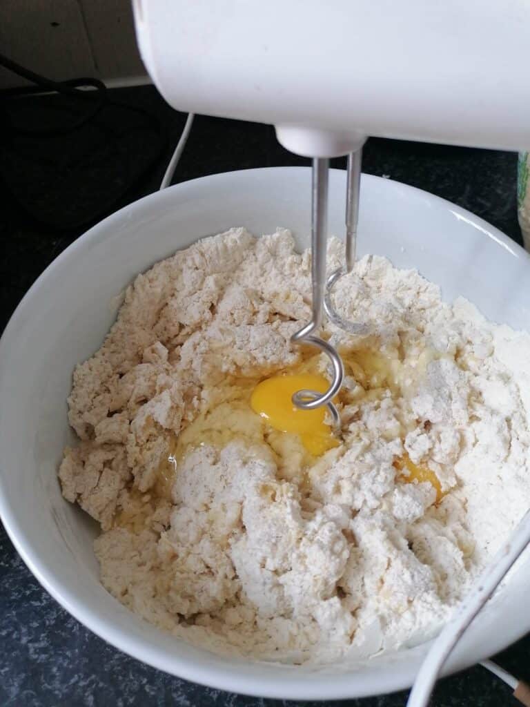 Add in eggs and mix the dough until fully incorporated